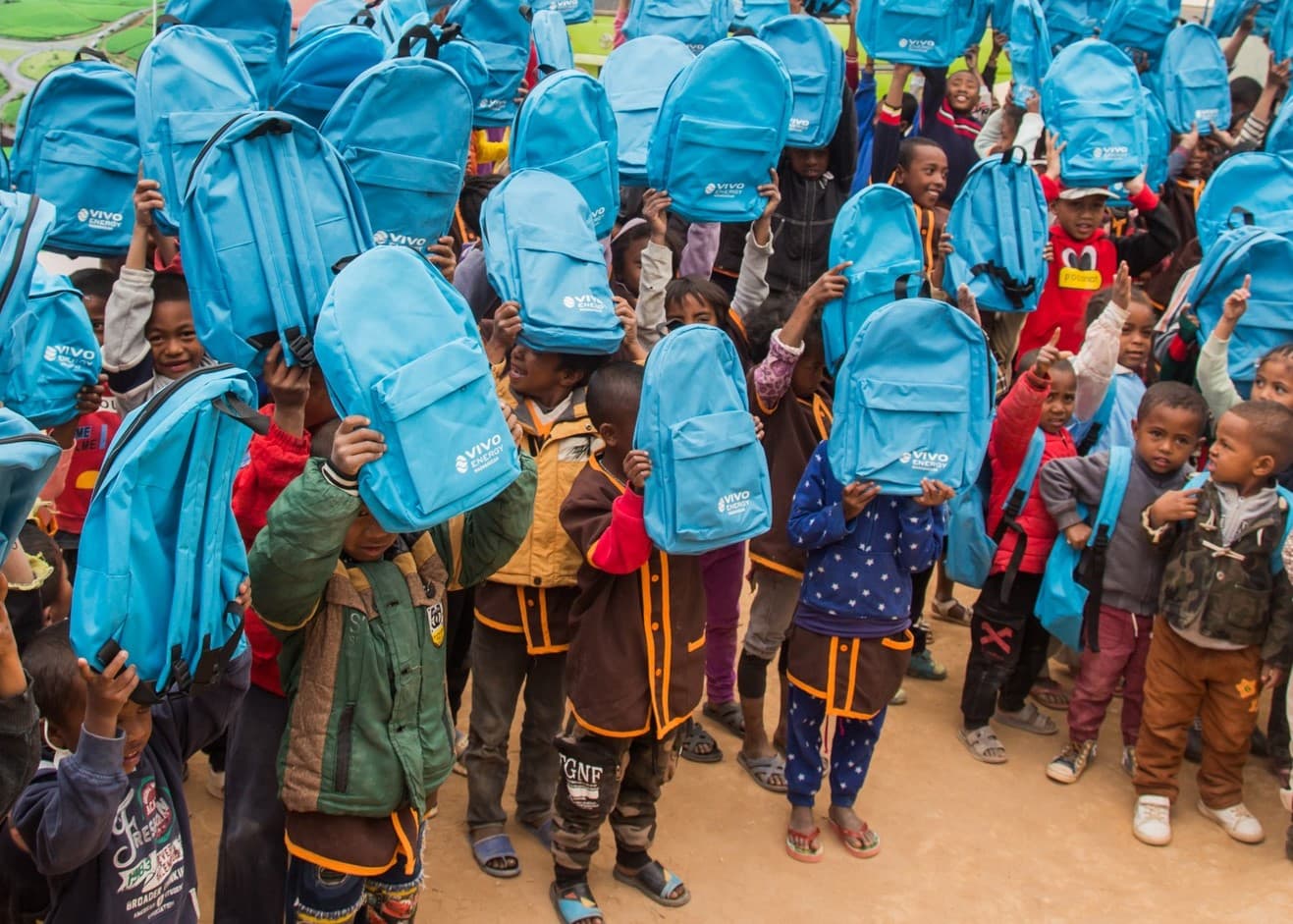 Enfants recevant des sacs scolaires lors d’une action